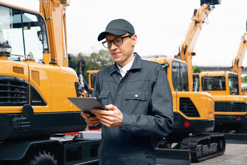 Aufkleber - Engineer with a digital tablet stands next to construction excavators
