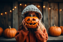 Kid Hugs Carved Halloween Pumpkin On Autumn Background.