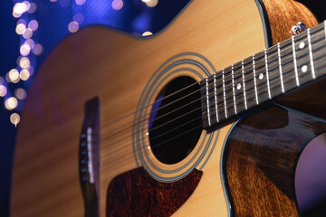 Wall Mural - Close-up, acoustic guitar on a dark background with bokeh lights.