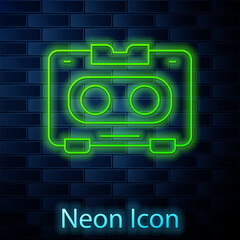 Wall Mural - Glowing neon line Retro audio cassette tape icon isolated on brick wall background. Vector