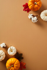 Wall Mural - Frame of pumpkins, maple leaves, cotton on brown background. Happy Thanksgiving poster template. Flat lay, top view, copy space.