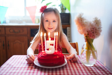 Wall Mural - Happy little girl celebrating her fifth birthday and making a wish