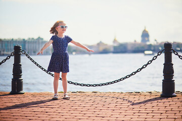 Wall Mural - Adorable preschooler girl walking on the Neva embankment in St. Peterburg, Russia