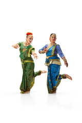 Wall Mural - Sattriya dance. Women, in beautiful traditional indian dresses dancing against white studio background. Concept of beauty, fashion, India, traditions, lifestyle, choreography, art. Ad