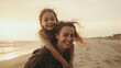 © dinastya - Happy mother giving daughter piggyback ride at sandy summer beach. Happy family day on the seashore. Summer fun.