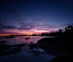 Wall Mural - Beautiful seascape with colorful sky. Sunset and night time on the rock beach.