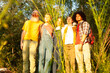 © Bjorn B - A group of diverse, multi-ethnic millennial friends stands amidst the captivating beauty of nature during the golden hour. As the sun bathes the surroundings in warm, enchanting light, these friends