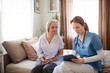 © Halfpoint - Female caregiver doing regular check-up of senior woman in her home.