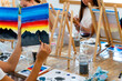 © Alfonso Soler - Painting Workshop. Close-up of students painting a canvas on easels.