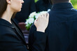 © pressmaster - Close-up of young supporting woman consoling her grieving friend wearing mourning clothes at funeral of his wife or other family member