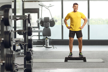 Canvas Print - Man standing on a step aerobic platform at a gym