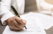 © Bussarin - US IRS 1040 form or  US Individual income tax Concept,accountant holding pen working on calculator business with data accounting documents and a laptop, pay tax in 2023 years,new year 2024 tax concept