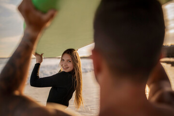 Wall Mural - Beautiful Young Woman Surfing With Her Boyfriend On The Beach