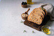 Homemade sourdough ciabatta slice bread with olives and rosemary on a white abstract table. Artisan bread