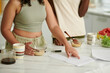 © DragonImages - Cropped image of students eating breakfast and preparing for exams