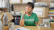 © Krakenimages.com - Hispanic woman with amputee arm volunteer smiling confident sitting on table at charity center