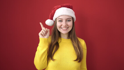 Sticker - Young blonde woman wearing christmas hat with idea gesture over isolated red background