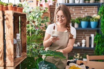 Sticker - Young blonde woman florist taking picture of plants at florist