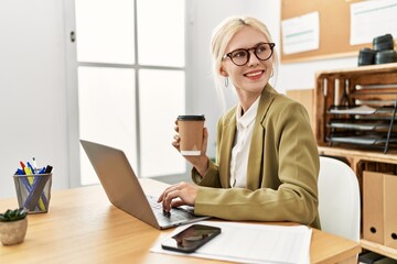 Canvas Print - Young blonde woman business worker using laptop drinking coffee at office