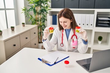 Wall Mural - Young blonde woman doctor holding urine test tubes at clinic