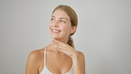 Wall Mural - Young blonde woman smiling confident touching face over isolated white background