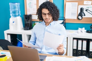 Poster - Young latin man business worker using laptop reading document at office