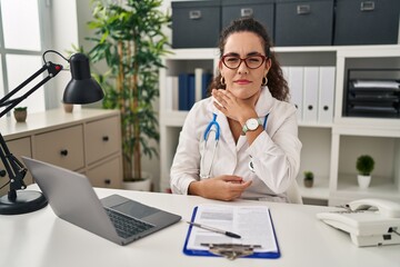 Sticker - Young hispanic woman wearing doctor uniform and stethoscope cutting throat with hand as knife, threaten aggression with furious violence