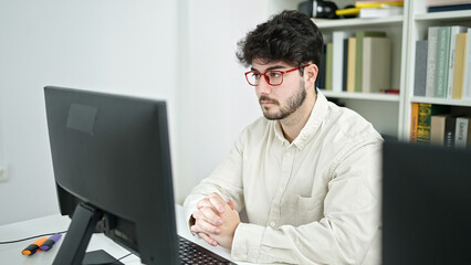 Sticker - Young hispanic man student using computer studying at library university