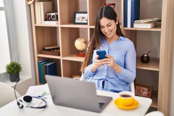 Wall Mural - Young woman using smartphone working at home