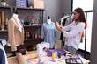 © Krakenimages.com - Young african american woman tailor make photo by smartphone to jacket at atelier