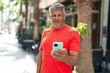 © Krakenimages.com - Middle age grey-haired man smiling confident using smartphone at street