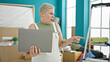 © Krakenimages.com - Middle age grey-haired woman using laptop standing at new home