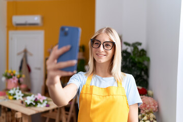 Canvas Print - Young blonde woman florist make selfie by smartphone at flower shop