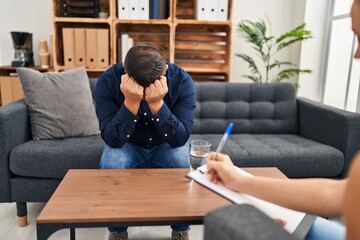 Canvas Print - Young latin man patient stressed having psychologist session at psychology clinic