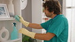 © Krakenimages.com - Young hispanic man cleaning shelving with a cloth at home