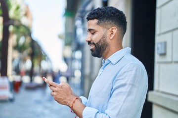 Sticker - Young arab man smiling confident using smartphone at street