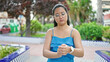 © Krakenimages.com - Young chinese woman wearing watch with serious expression at park