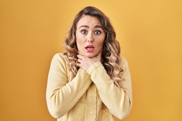 Sticker - Young caucasian woman standing over yellow background shouting and suffocate because painful strangle. health problem. asphyxiate and suicide concept.