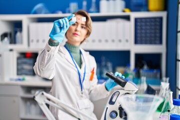 Wall Mural - Young woman scientist using microscope looking sample at laboratory