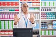 © Krakenimages.com - Middle age woman with tattoos working at pharmacy drugstore moving away hands palms showing refusal and denial with afraid and disgusting expression. stop and forbidden.
