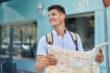 Sticker - Young hispanic man student smiling confident holding city map at street