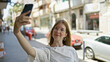 © Krakenimages.com - Young blonde woman smiling confident making selfie by the smartphone at street
