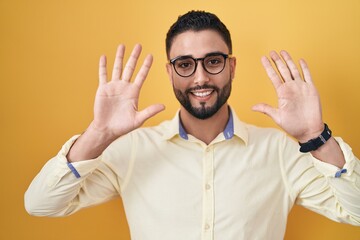 Sticker - Hispanic young man wearing business clothes and glasses showing and pointing up with fingers number ten while smiling confident and happy.