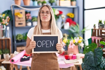 Poster - Young blonde woman working at florist holding open sign skeptic and nervous, frowning upset because of problem. negative person.