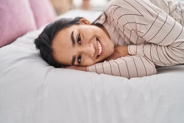 Poster - Young hispanic woman smiling confident lying on bed at bedroom