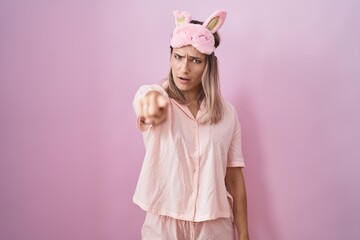 Canvas Print - Blonde caucasian woman wearing sleep mask and pajama pointing displeased and frustrated to the camera, angry and furious with you