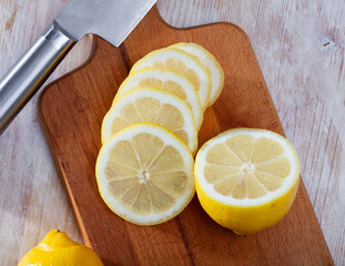 Wall Mural - Whole and sliced ripe organic lemons on wooden table. ..