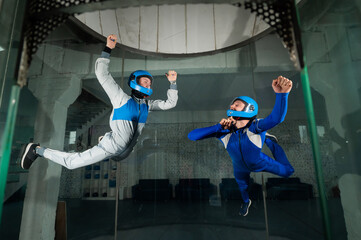 A man and a woman enjoy flying together in a wind tunnel. Free fall simulator