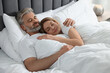 © New Africa - Lovely mature couple sleeping together in bed at home