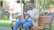 © stockbakers - Middle Aged Man Doing Online Shopping via phone while Sitting Outdoor
